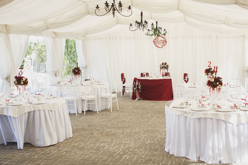 Tables set out in a marquee for a wedding.