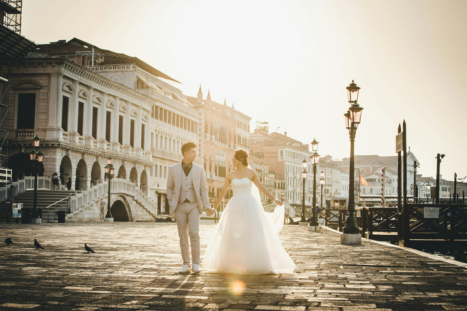 Couple walking through historic Venice following their wedding ceremony.