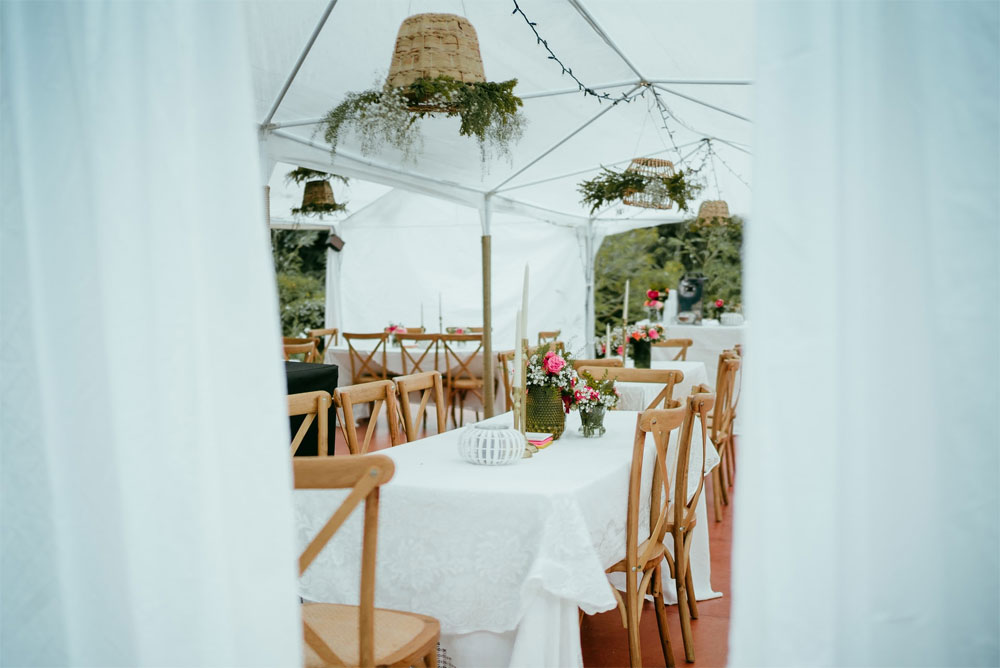 Tables in a marquee outdoors ready for a wedding.