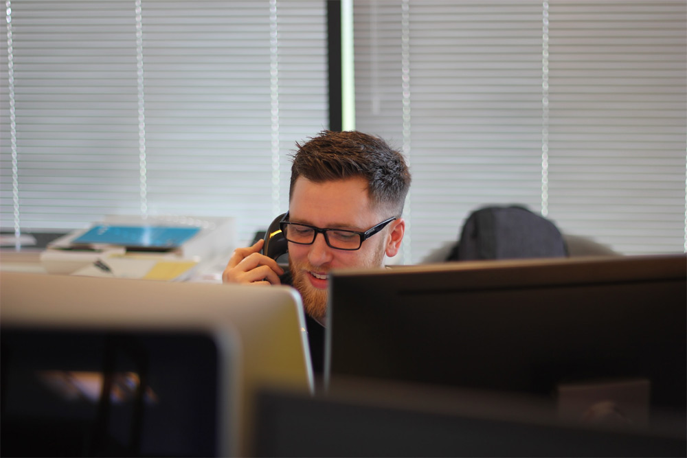 Contact Us - Man in call centre taking a telephone call from a customer.